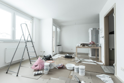 A room with a ladder, paint cans, and a pig