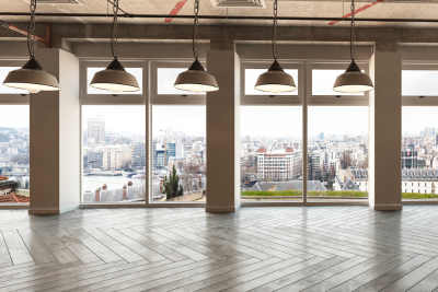 An empty room with large windows overlooking a city