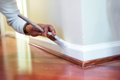 A person painting a wall with a paint roller